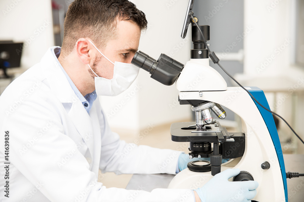 Chemist using microscope in a laboratory Chemist using microscope in a laboratory