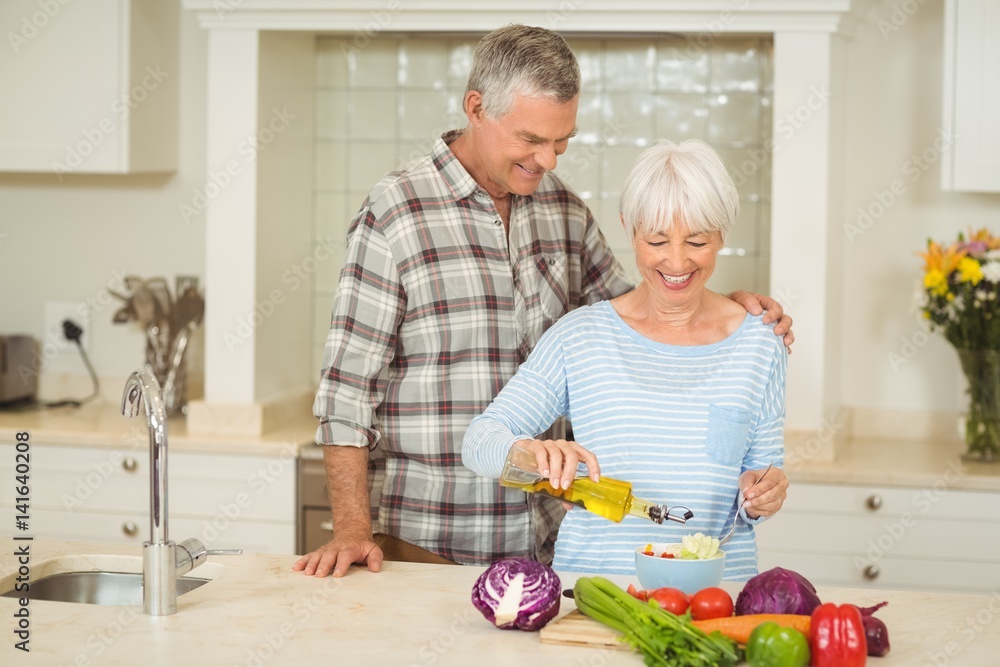 Senior couple preparing vegetable salad Senior couple preparing vegetable salad