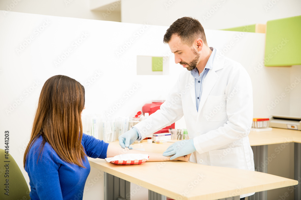 Obraz premium Doctor putting bandage on patient's arm