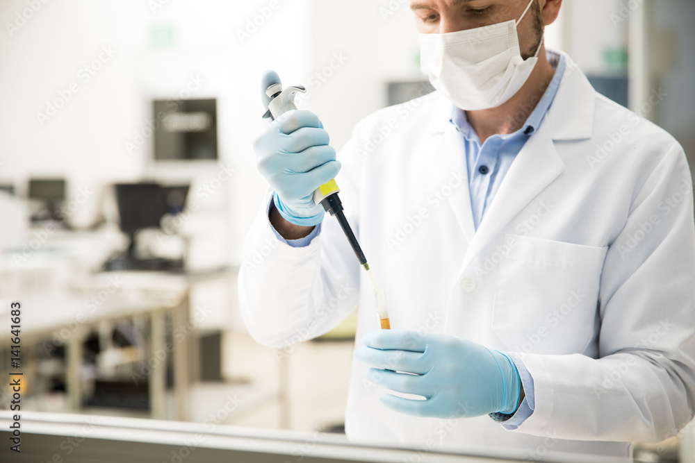 Chemist preparing a test with a pipette Chemist preparing a test with a pipette