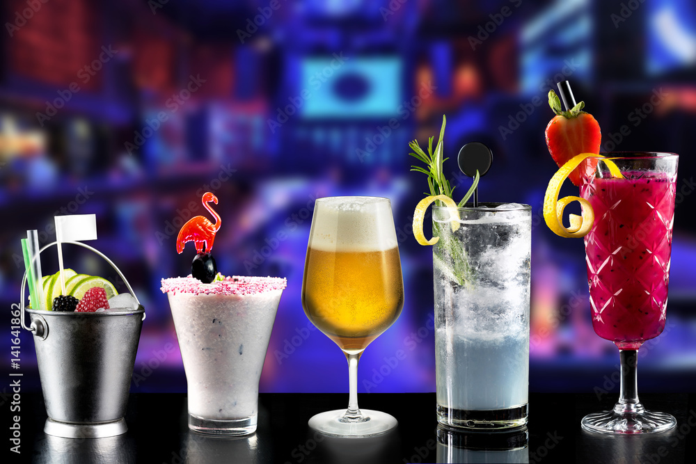modern rustic selection of cocktails drinks alcohol at bar counter with defocused background various colours glass