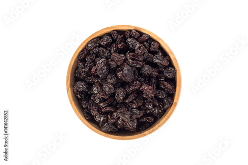 Dried raisins in wooden cup on white background.