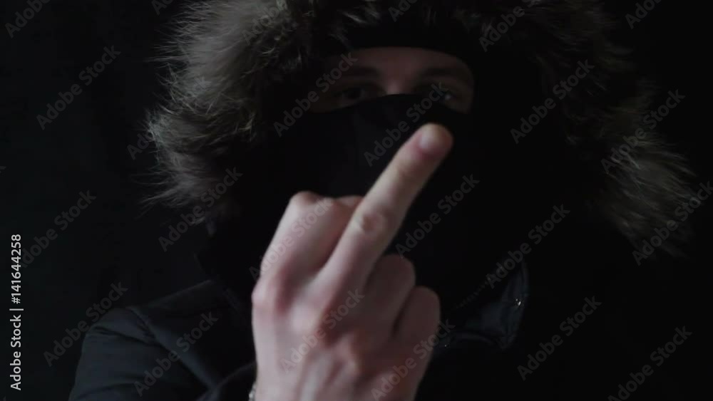 the masked robber shows to the camera the middle finger the masked robber shows to the camera the middle finger