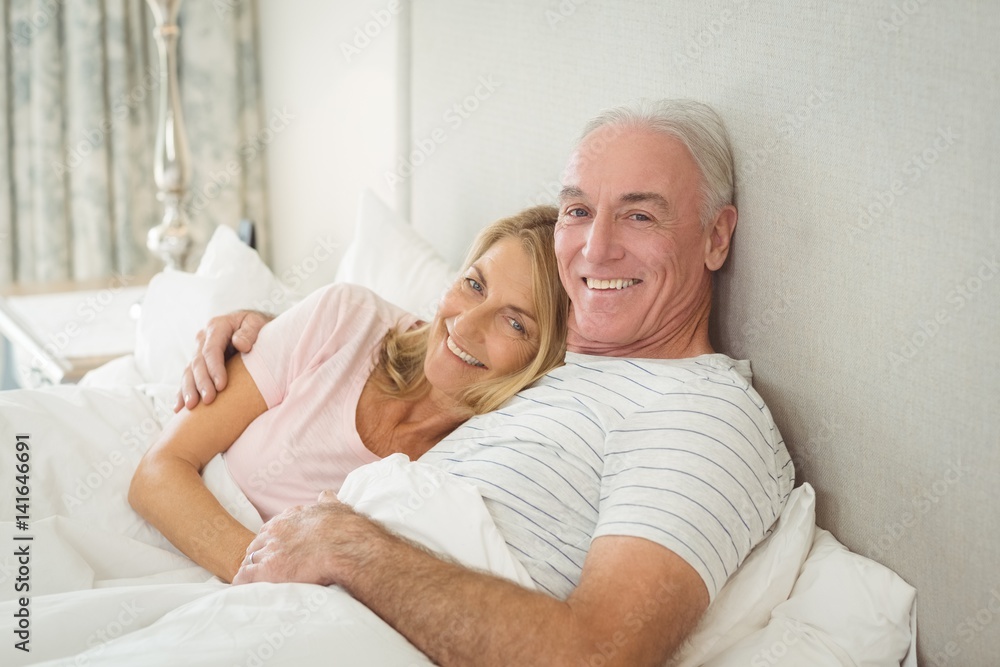 Obraz premium Senior couple embracing on bed 