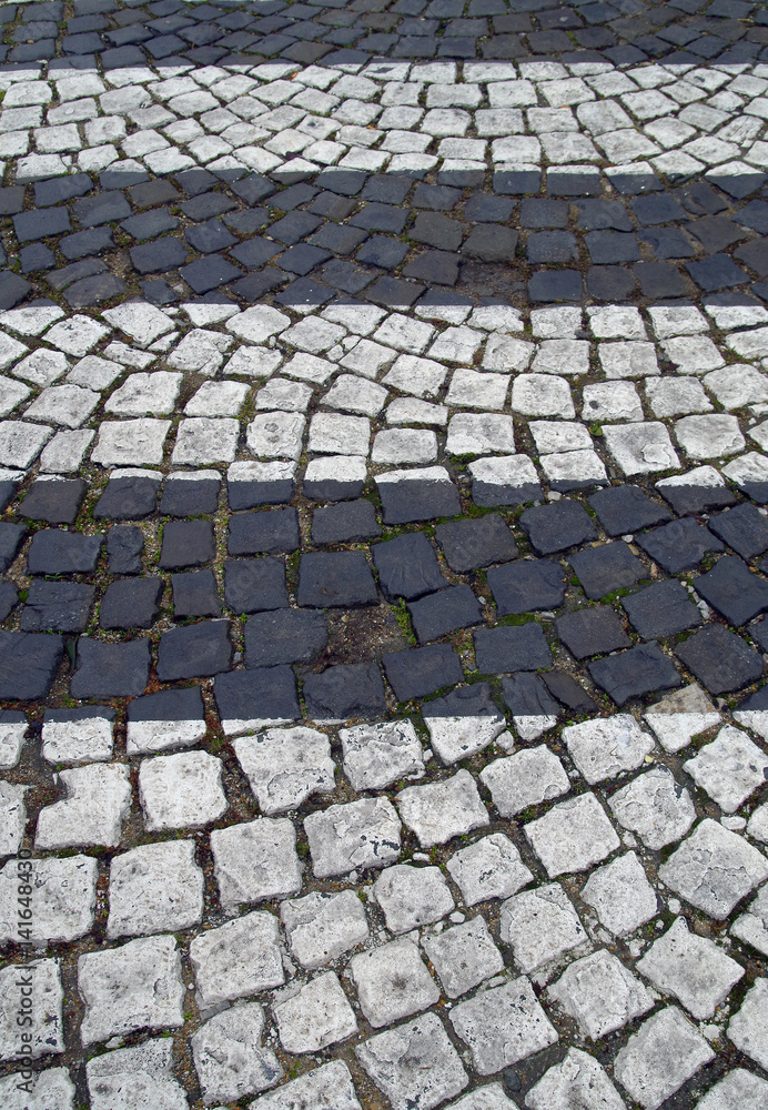 Fototapeta premium Black and white stripes on the pavement of stones.