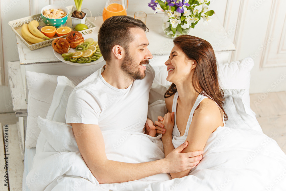Relaxed Couple in Bed in bedroom at home Relaxed Couple in Bed in bedroom at home