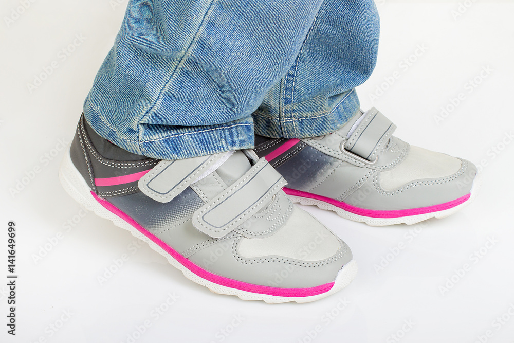 Young kid standing and wearing modern sport shoes Young kid standing and wearing modern sport shoes