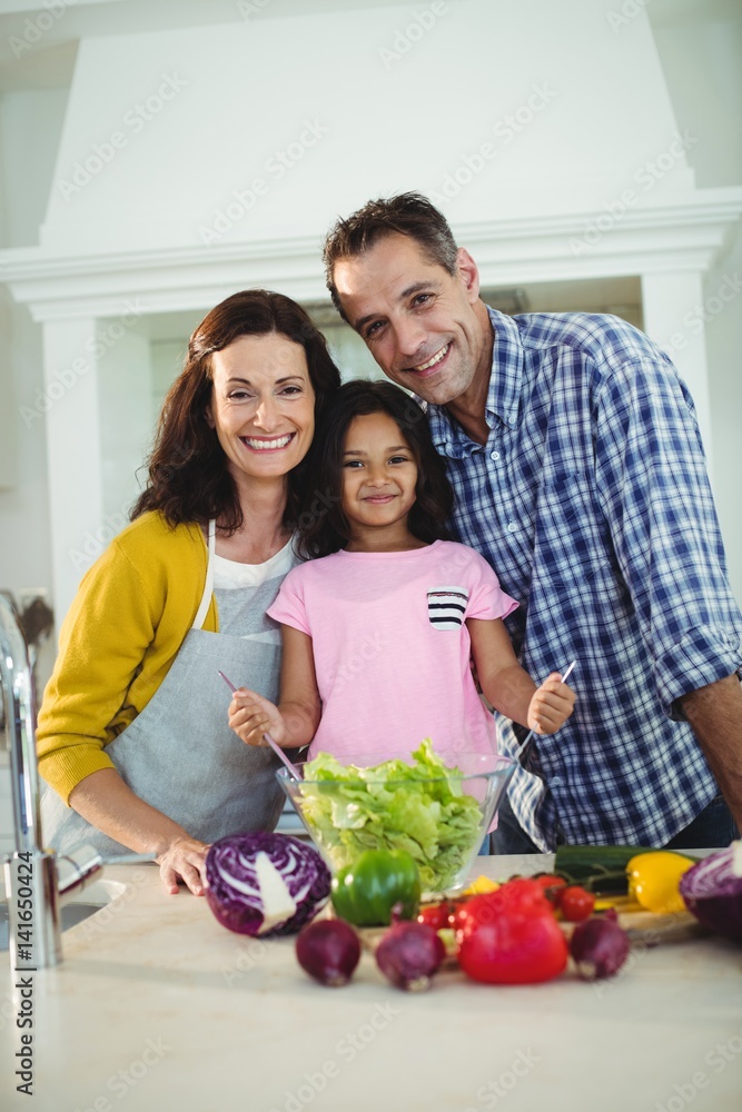 Portrait of parents and daughter preparing salad in kitchen Portrait of parents and daughter preparing salad in kitchen
