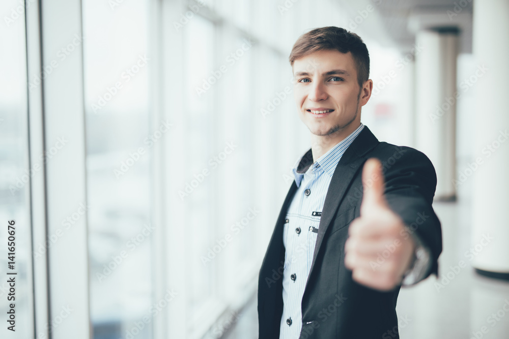 young business man going thumb up at the office hall young business man going thumb up at the office hall