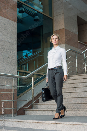 Beautiful business woman walking on stairs © ottochka