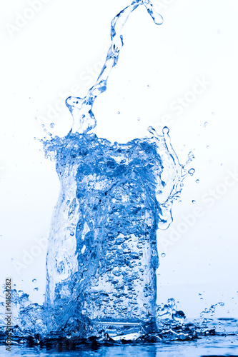Water pours into the glass, monochromatic background, studio light