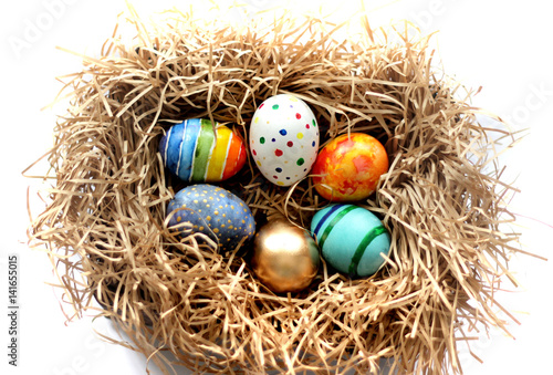 Easter colorful eggs in the nest on white background.