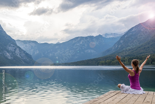 Woman meditating at the lake