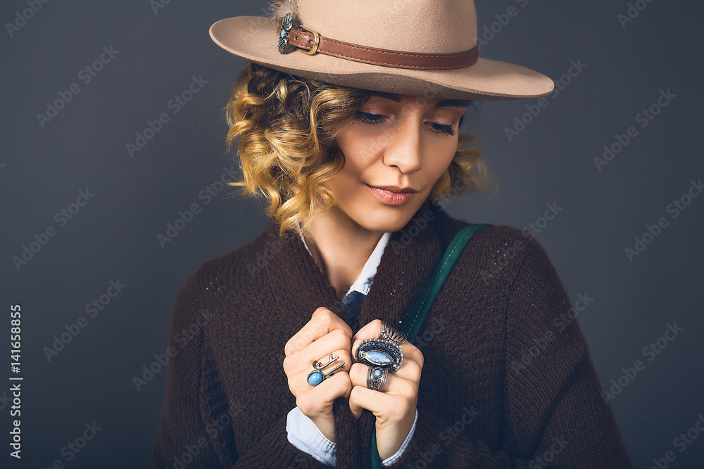 Obraz premium Fashion lifestyle portrait of sensual beautiful young woman in hat, natural beauty face, skin care, bright sexy make up, traveling mood,curly hair,stylish look,red lips,beauty make up
