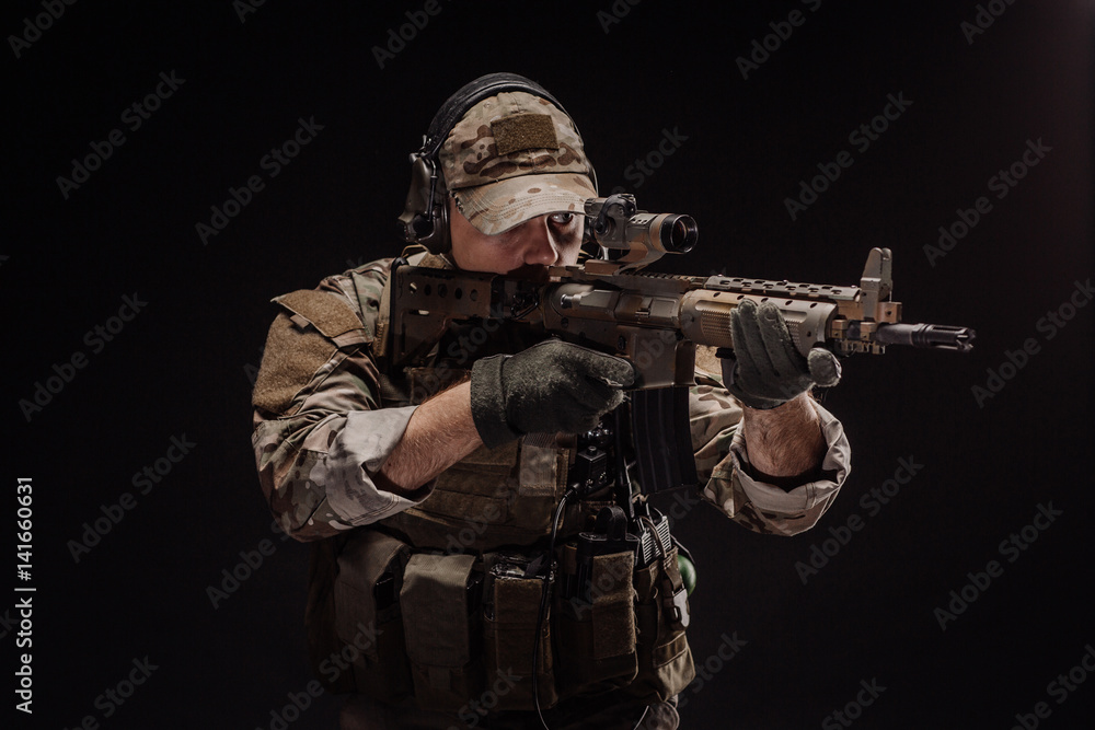 Portrait soldier or private military contractor holding sniper rifle. war, army, weapon, technology and people concept. Image on a black background.
