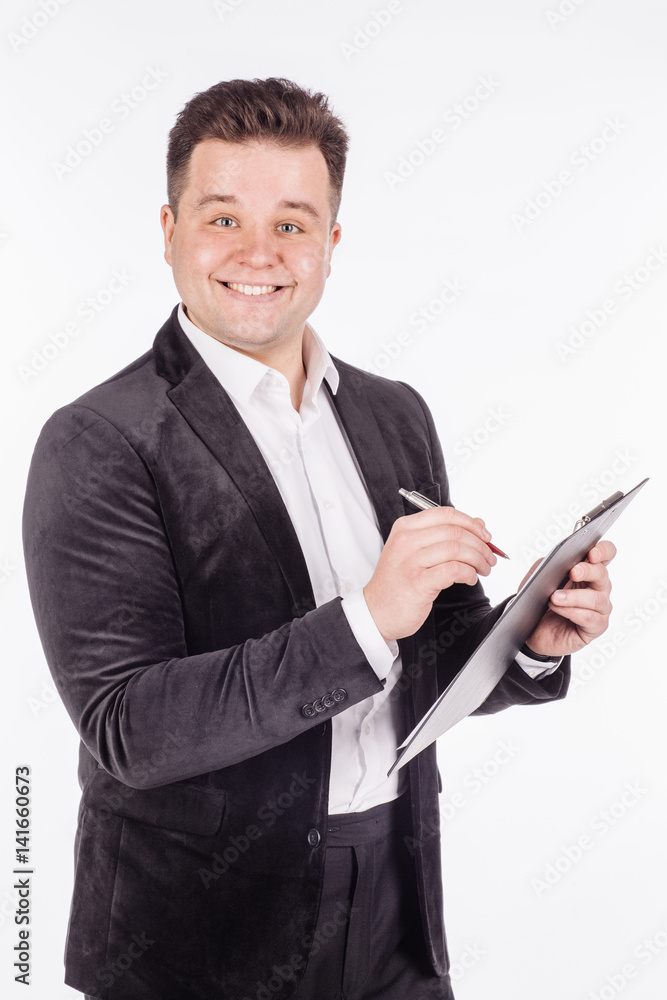 young business man standing and writing in folder on a white background. young business man standing and writing in folder on a white background.