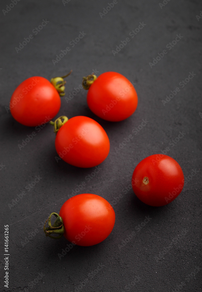 Fresh cherry tomatoes on a black matte background Fresh cherry tomatoes on a black matte background