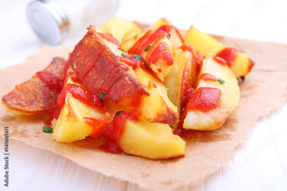 Baked potatoes with ketchup on a white background Baked potatoes with ketchup on a white background