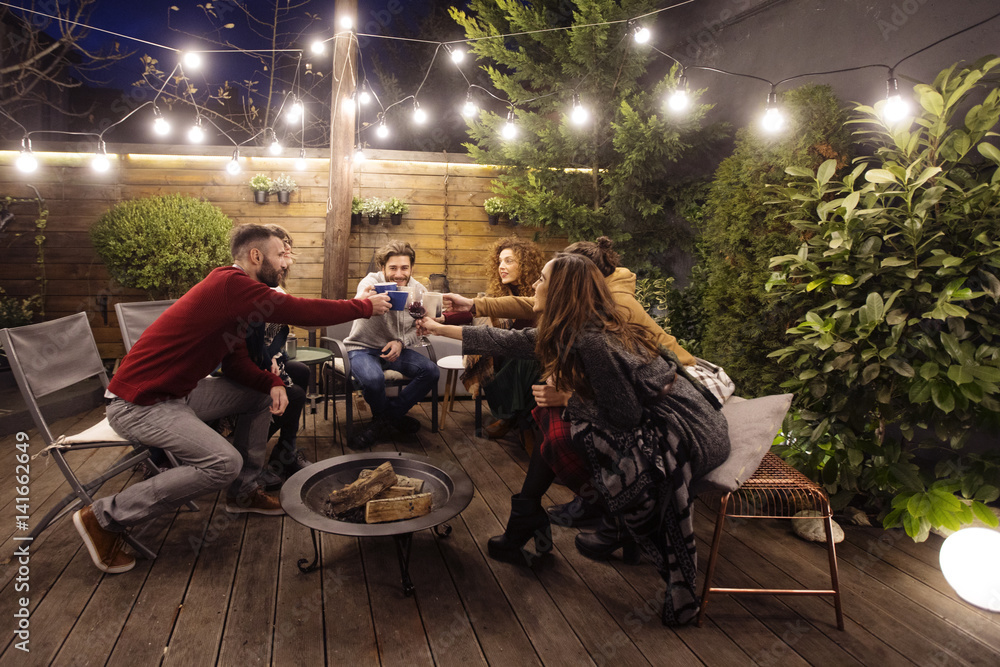 Happy friends toasting drinks in party at night Happy friends toasting drinks in party at night