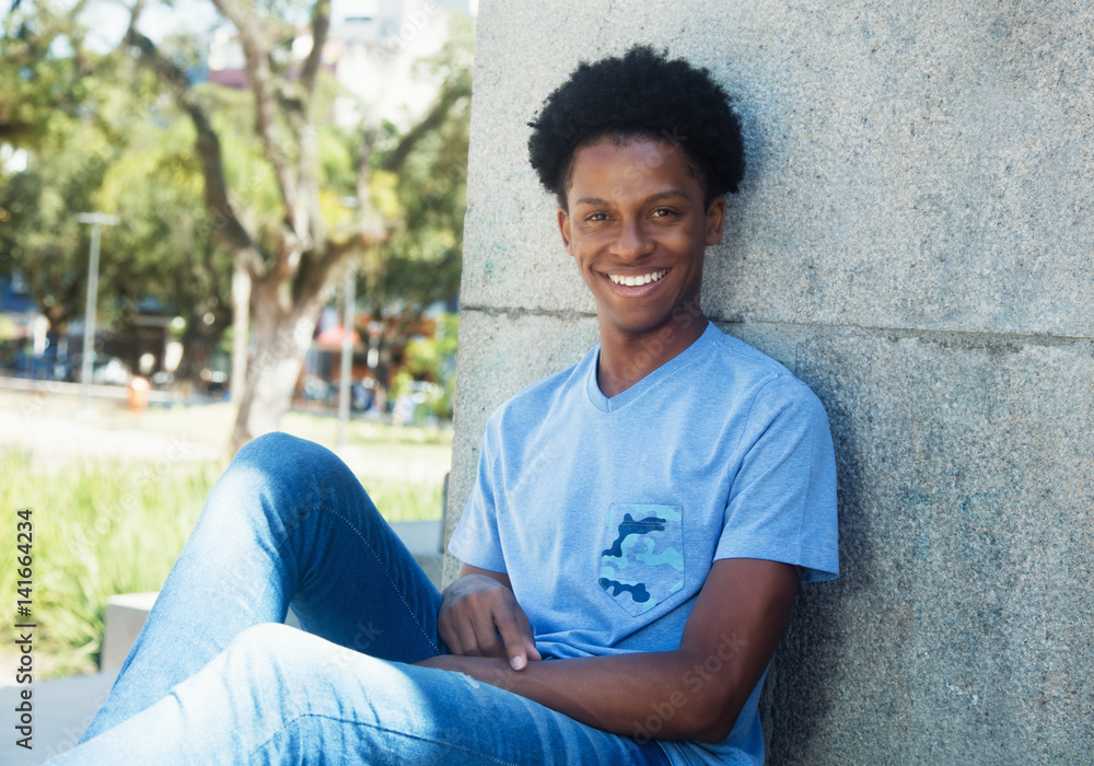 Obraz premium Junger Afrikaner entspannt im Park