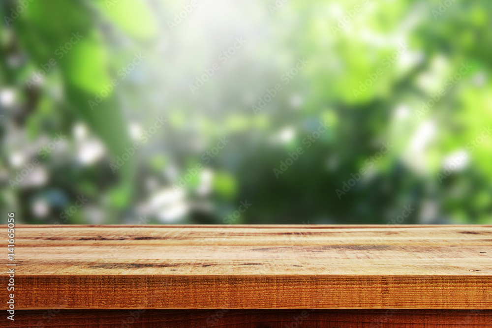 Wooden table and blurred green forest background. Wooden table and blurred green forest background.