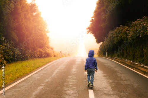 Young Boy Walking on an Empty Road