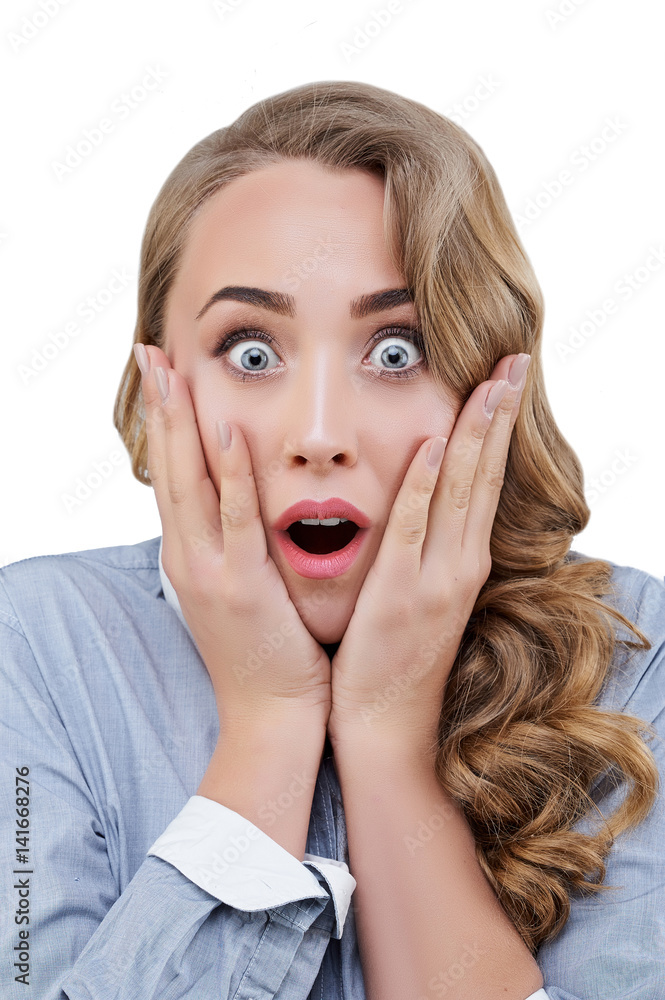 Unbelievable close up portrait of a young surprised woman with opened eyes and mouth touching her cheeks Unbelievable close up portrait of a young surprised woman with opened eyes and mouth touching her cheeks