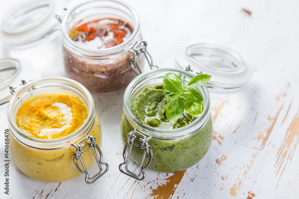 Selection of colorful hummus in jars Selection of colorful hummus in jars