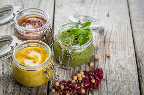 Selection of colorful hummus in jars