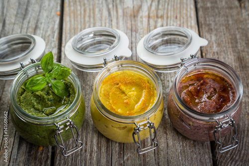 Selection of colorful hummus in jars