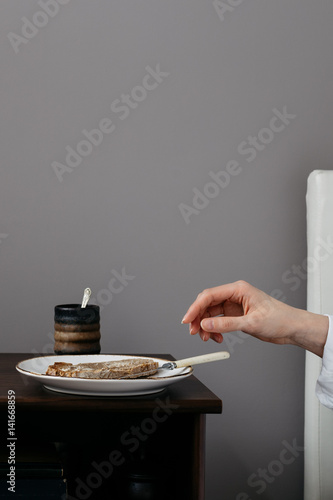 Hand Reaching for Toast on Bedside Cabinet