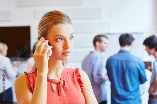 Junge Geschäftsfrau beim Telefonieren