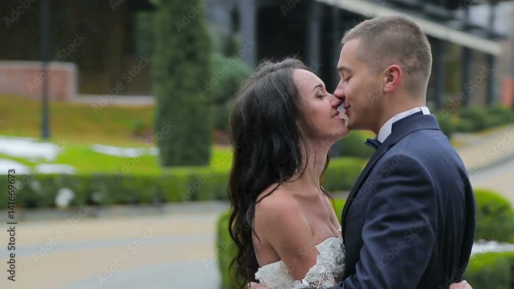 Groom and bride joined in a kiss. The camera flies them. slow-motion Groom and bride joined in a kiss. The camera flies them. slow-motion