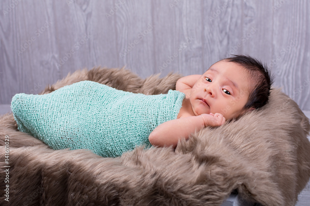 Adorable little newborn baby girl swaddled in a knit wrap Adorable little newborn baby girl swaddled in a knit wrap