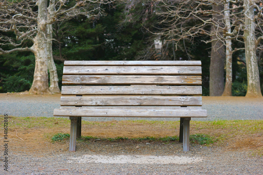 An old wood bench with blur forest background in the park, Japan An old wood bench with blur forest background in the park, Japan