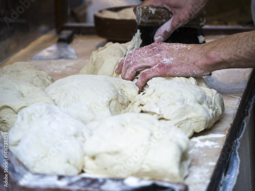 Baker kneading dough. Homemade bread. Hands preparing bread dough on a wooden table. Preparing traditional homemade bread. Man hands kneading fresh dough for making bread