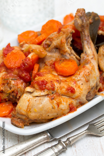 rabbit stew with carrot and tomato on white dish