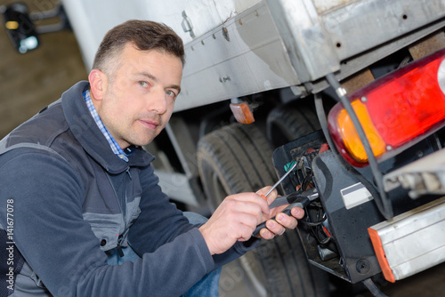 delivery man setting truck platform for loading