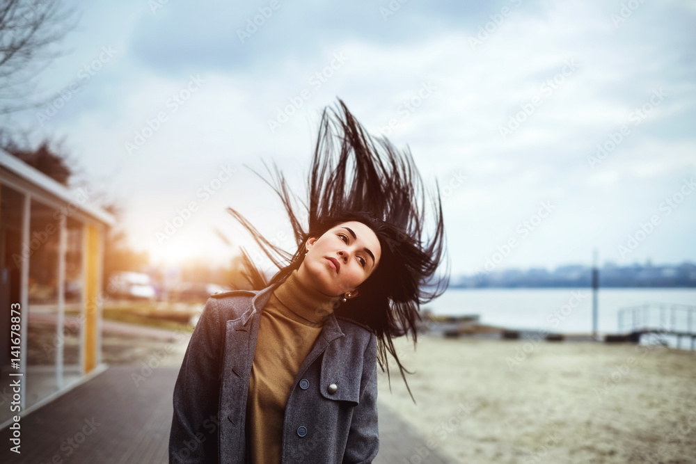 brunette woman outdoor with blowing up hair