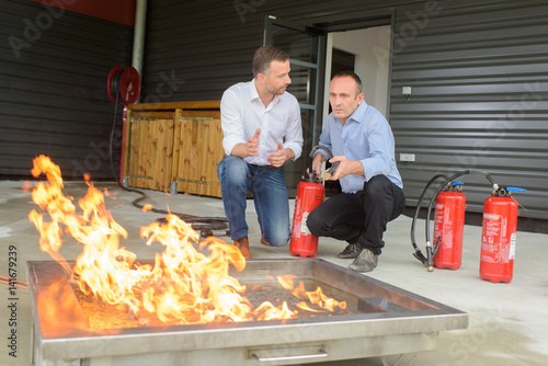 Fotografie Men training with fire extinguishers