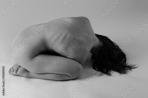 Faceless Nude Woman Curled Up on Floor photo