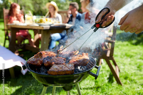 Canvas Print man cooking meat on barbecue grill at summer party