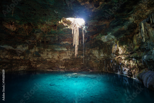 Photo Sunbeams penetrating in opening of Blue cenote