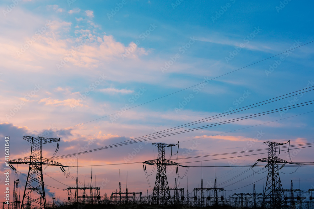 The silhouette of the evening electricity transmission pylon.