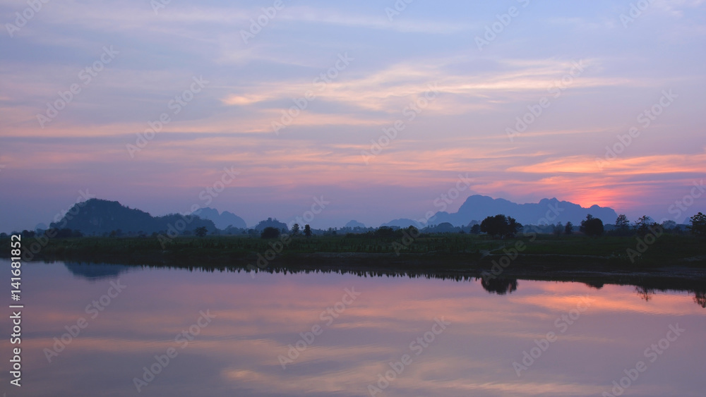 Beautiful tropical sunset over the Salween river with mountains on the background, Myanmar