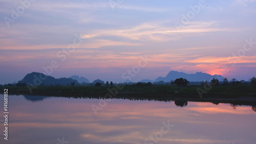 Beautiful tropical sunset over the Salween river with mountains on the background, Myanmar © Olga