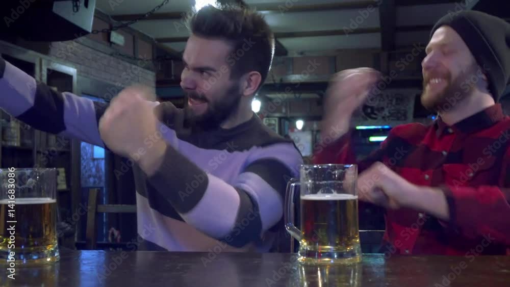 Vidéo Stock Two bearded friends rooting for their sport team at the pub ...