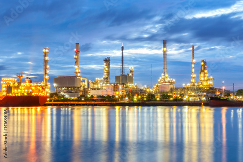 Oil refinery at twilight with dark sky background.