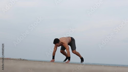 Athletischer Mann macht burpees am Meer photo