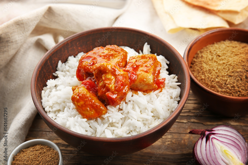 Bowl with delicious chicken tikka masala and rice on table Bowl with delicious chicken tikka masala and rice on table